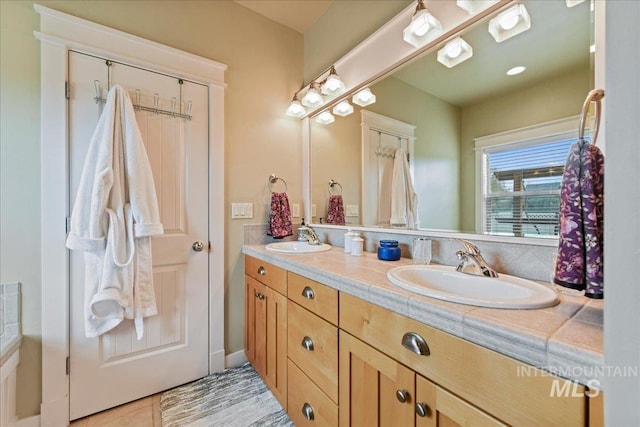 full bathroom featuring a sink, tile patterned floors, and double vanity