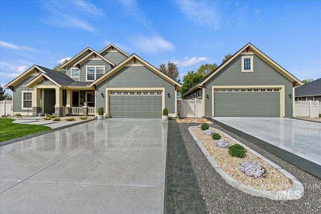 view of front of home with a garage, fence, a porch, and driveway