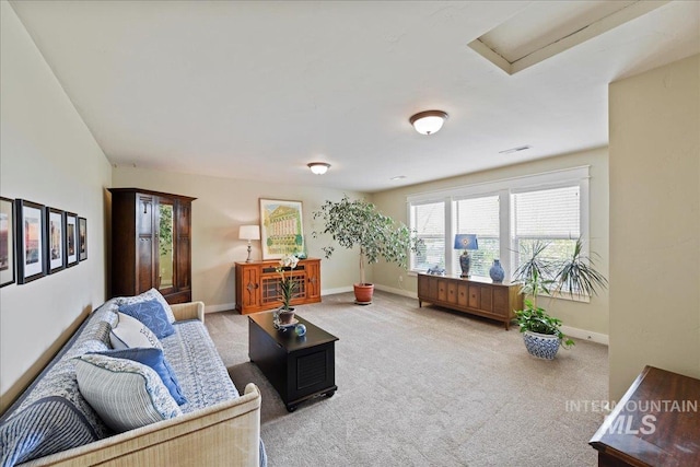 living room with carpet floors, attic access, and baseboards