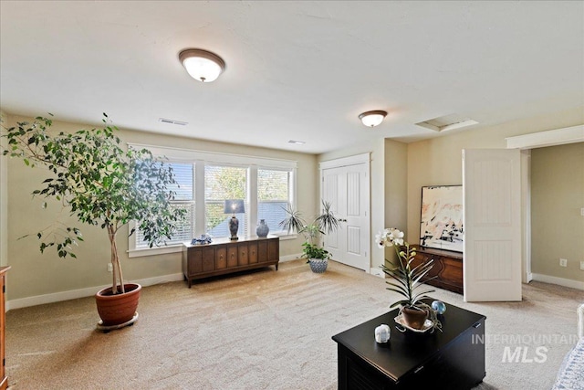 living area with attic access, baseboards, visible vents, and carpet