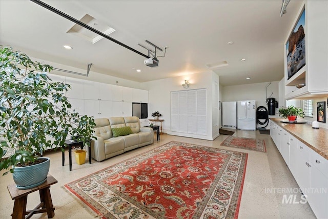 living area featuring light speckled floor, recessed lighting, and a garage