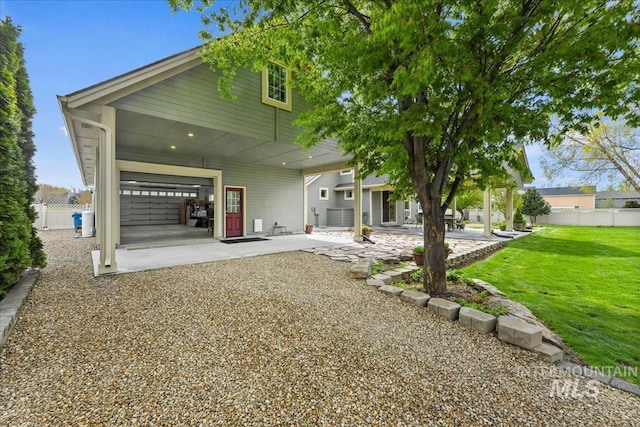 rear view of house with a lawn, fence, and a patio