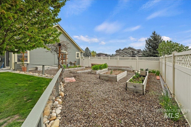 view of yard with fence and a vegetable garden