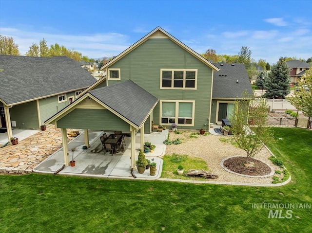 back of property featuring a patio area, fence, a yard, and roof with shingles