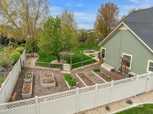 view of side of property with a garden, fence, and a yard