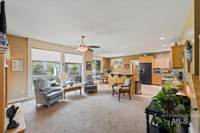 living room featuring a ceiling fan, recessed lighting, and light colored carpet