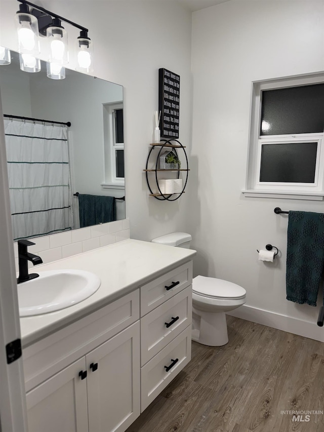 815 Emerald Dr N, Kimberly, ID 83341 - full bathroom featuring vanity, baseboards, toilet, and wood finished floors
