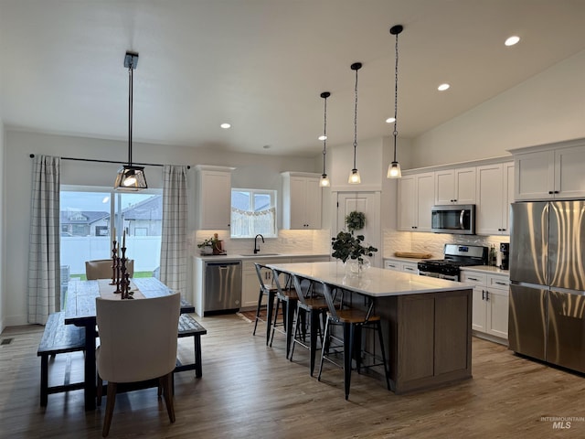815 Emerald Dr N, Kimberly, ID 83341 - kitchen featuring a breakfast bar, light countertops, a center island, stainless steel appliances, and backsplash