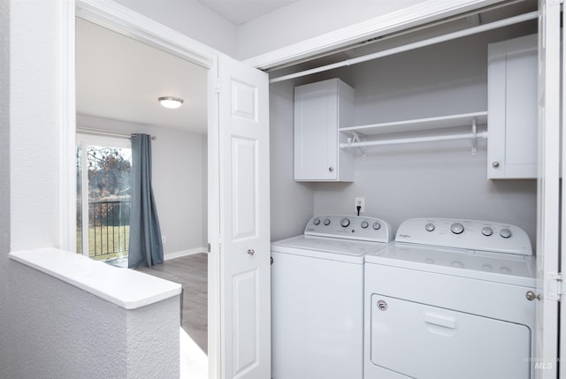 laundry room with cabinets, washer and clothes dryer, and wood-type flooring