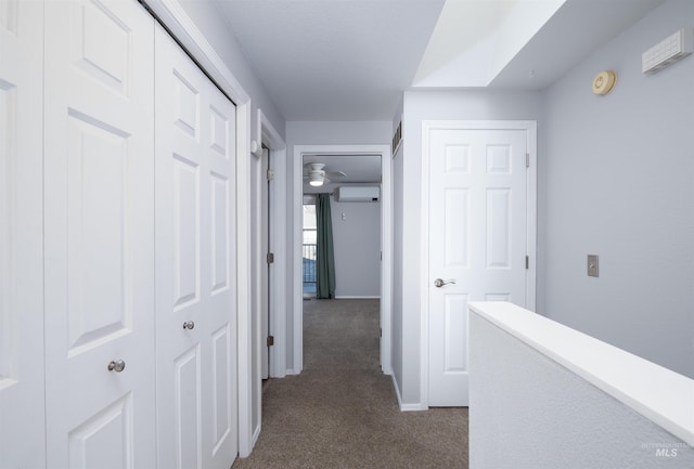 corridor with dark carpet and a wall unit AC