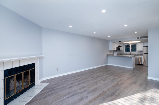 unfurnished living room with light wood-type flooring and a fireplace