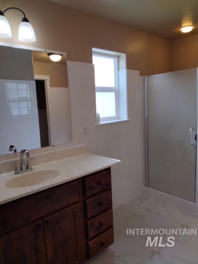 841 Gregory Way, Twin Falls, ID 83301 - bathroom featuring vanity, a shower stall, and marble finish flooring