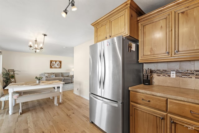 1934 N Cribbens St, Boise, ID 83713 - kitchen featuring freestanding refrigerator, decorative backsplash, a chandelier, light wood-type flooring, and light countertops