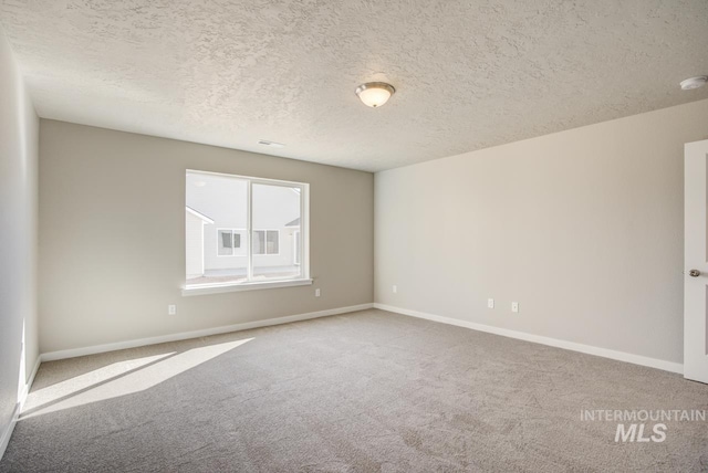 spare room with carpet floors and a textured ceiling