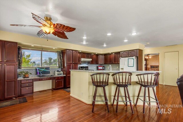 368 W King Rd, Kuna, ID 83634 - kitchen featuring white fridge with ice dispenser, a ceiling fan, decorative backsplash, dark wood-style floors, and recessed lighting