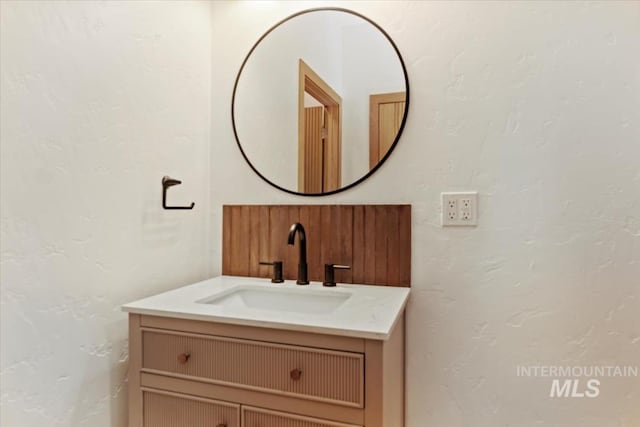 bathroom with a textured wall and vanity