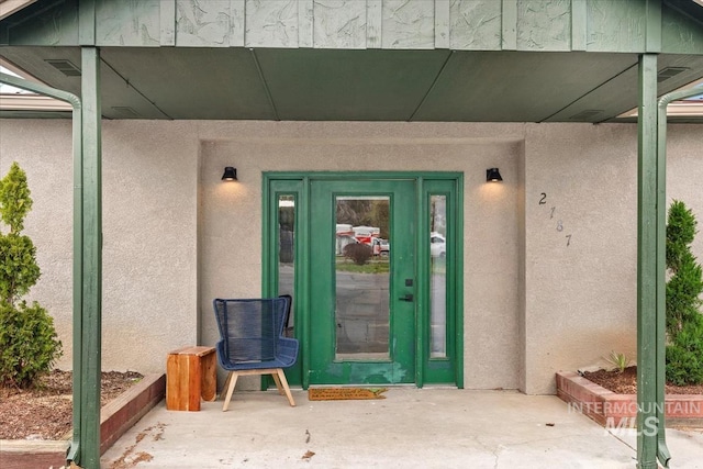 doorway to property featuring stucco siding