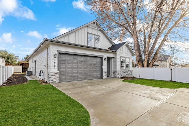 view of front of home featuring central AC, a front lawn, and a garage