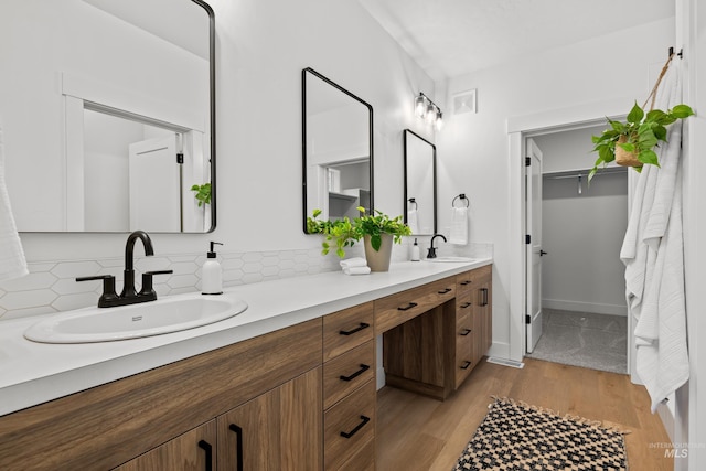 bathroom featuring hardwood / wood-style flooring, backsplash, and vanity