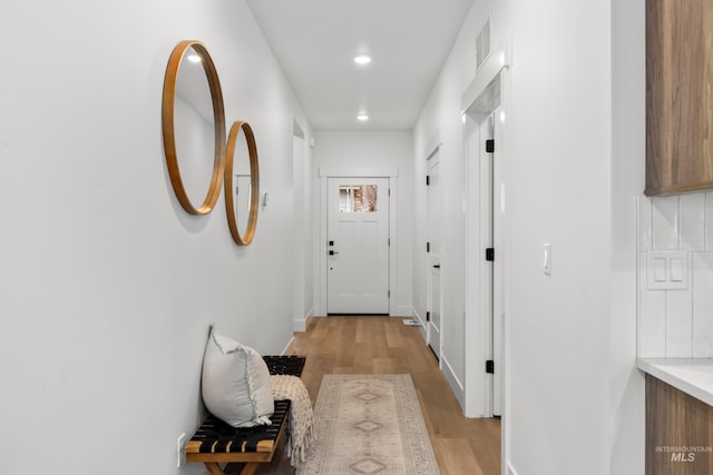 hallway with light hardwood / wood-style floors