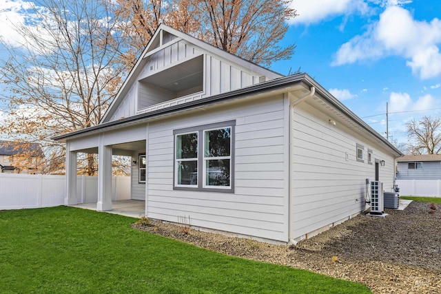 back of house featuring a lawn, central AC unit, and a patio