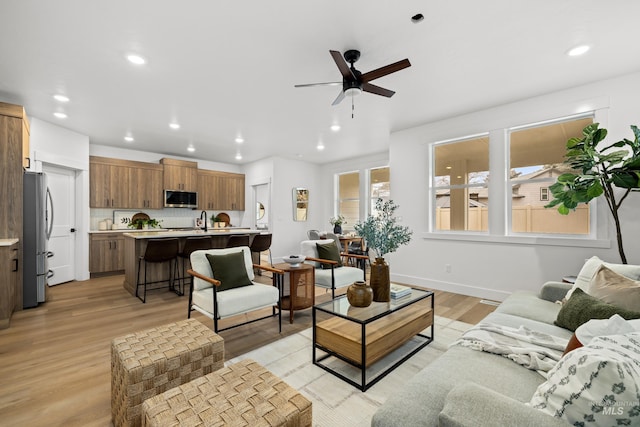 living room featuring light hardwood / wood-style floors and ceiling fan