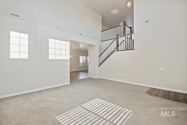 4217 S Leaning Tower Ave, Meridian, ID 83624 - unfurnished living room with carpet floors, stairway, and high vaulted ceiling