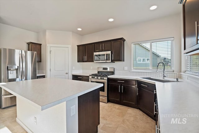 4217 S Leaning Tower Ave, Meridian, ID 83624 - kitchen featuring appliances with stainless steel finishes, light countertops, dark brown cabinetry, a kitchen island, and light tile patterned floors