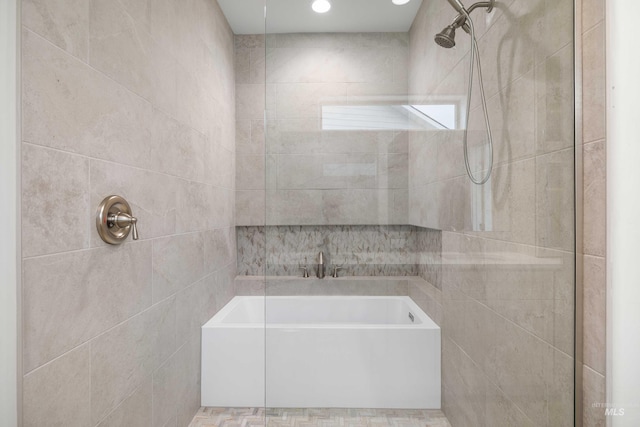 bathroom featuring tile walls, tiled shower, and a bath