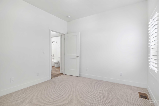 unfurnished bedroom with light colored carpet, visible vents, and baseboards