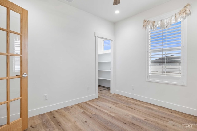empty room with wood finished floors, baseboards, ceiling fan, and recessed lighting
