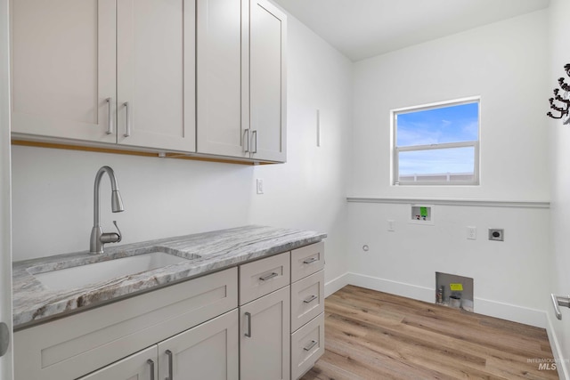 washroom featuring a sink, cabinet space, light wood finished floors, electric dryer hookup, and washer hookup