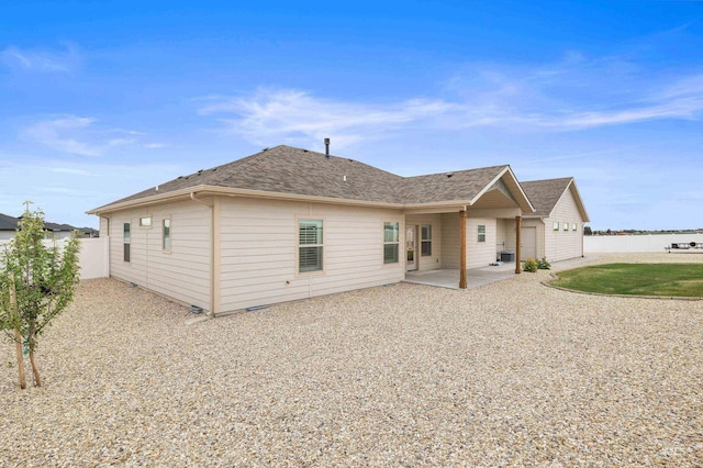rear view of property featuring central AC unit, fence, a patio, and a shingled roof