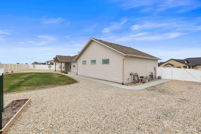 rear view of house featuring a yard, a fenced backyard, and a garden