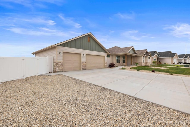 single story home with fence, an attached garage, driveway, a front lawn, and board and batten siding