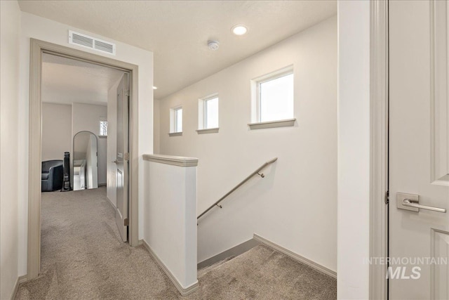 hallway with baseboards, visible vents, recessed lighting, light carpet, and an upstairs landing