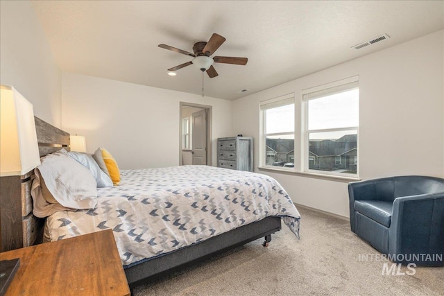 bedroom with visible vents, a ceiling fan, and carpet flooring