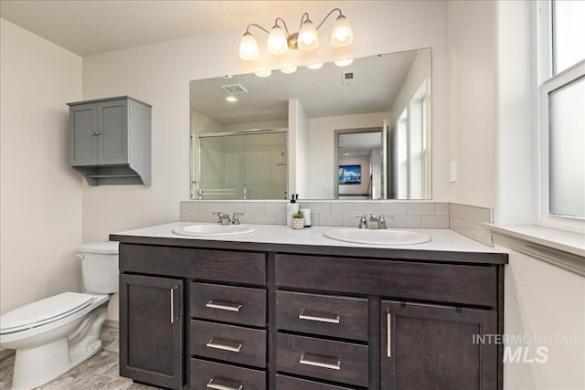 full bath with a shower stall, toilet, visible vents, and a sink