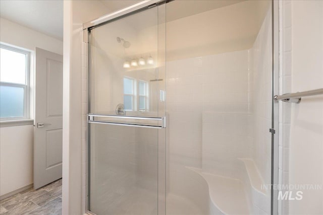 full bath featuring a stall shower and wood finished floors