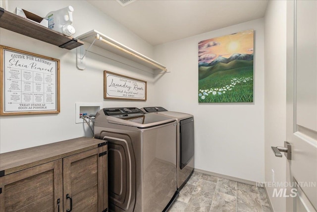 clothes washing area with baseboards, laundry area, and washer and clothes dryer