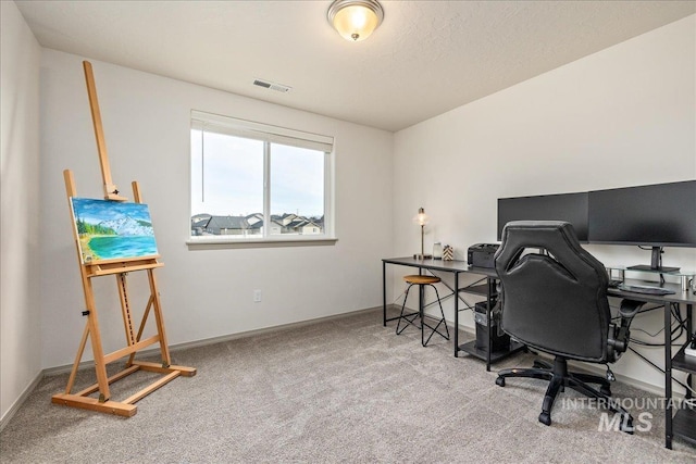 carpeted office space featuring visible vents and baseboards