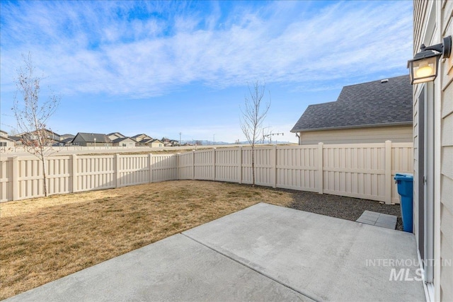 view of yard with a residential view, a fenced backyard, and a patio area