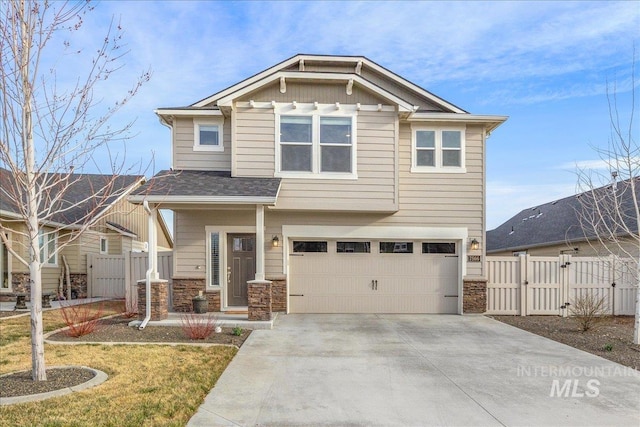 craftsman house with a gate, stone siding, fence, concrete driveway, and a garage