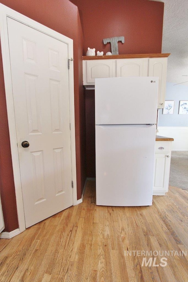16696 Snowgoose St, Nampa, ID 83687 - kitchen featuring freestanding refrigerator, white cabinets, and light wood finished floors
