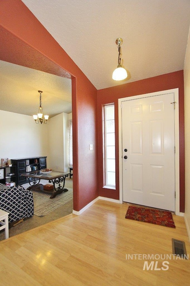 16696 Snowgoose St, Nampa, ID 83687 - foyer entrance with wood finished floors, vaulted ceiling, and a chandelier