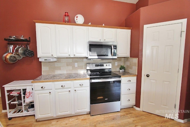 16696 Snowgoose St, Nampa, ID 83687 - kitchen with appliances with stainless steel finishes, decorative backsplash, white cabinetry, and light wood-type flooring
