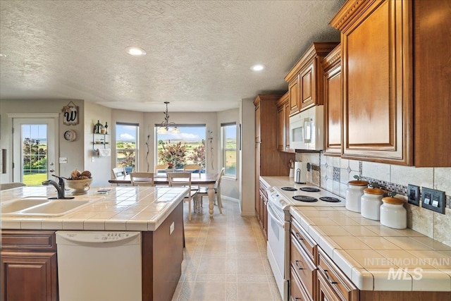 2020 Widner Rd, Midvale, ID 83645 - kitchen featuring white appliances, brown cabinets, plenty of natural light, backsplash, and a textured ceiling