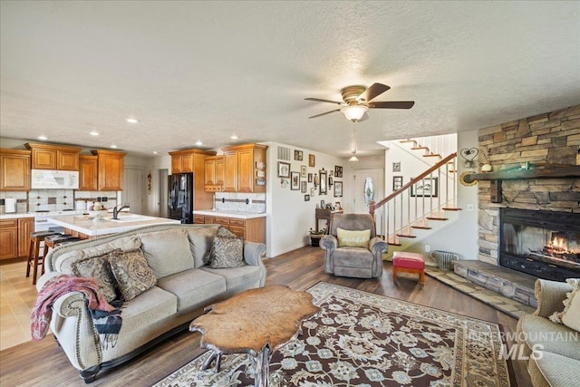 2020 Widner Rd, Midvale, ID 83645 - living room with a ceiling fan, stairway, recessed lighting, light wood-style flooring, and a stone fireplace