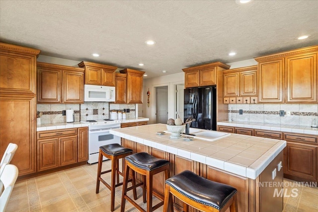 2020 Widner Rd, Midvale, ID 83645 - kitchen with white appliances, brown cabinetry, recessed lighting, a center island with sink, and decorative backsplash