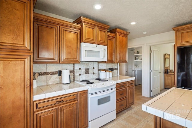 2020 Widner Rd, Midvale, ID 83645 - kitchen featuring white appliances, tile counters, washer / clothes dryer, brown cabinets, and recessed lighting